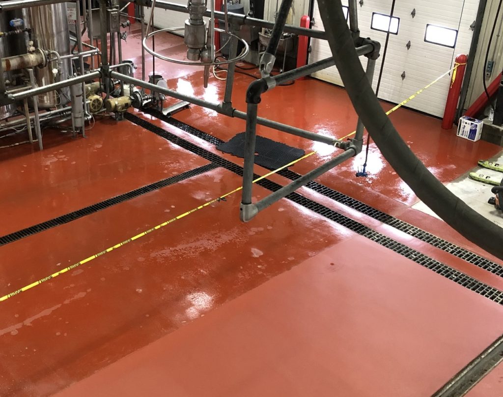 Red urethane concrete flooring installed in a truck wash facility